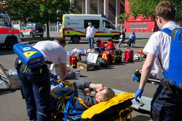 MANV-Übung in Mainz: Katastrophenschutz und Kliniken trainieren Transportorganisation Einsatzkräfte des Katastrophenschutzes, des Rettungsdienstes sowie Mitarbeitende der beteiligten Krankenhäuser übten an der MEWA Arena die Bewältigung eines Massenanfalls von Verletzten (MANV). Grundlage der Übung war ein angenommener Tribüneneinsturz im Mainzer Stadion. Im Fokus stand die Transportorganisation, bei der registrierte und gesichtete Verletztendarsteller entsprechend ihrer Behandlungsdringlichkeit geeigneten Rettungsmitteln und Krankenhäusern zugewiesen wurden. Parallel trainierten die beteiligten Kliniken die Aufnahme und Versorgung einer größeren Anzahl von Patienten. Ziel der Übung war die Überprüfung von Kommunikationswegen,