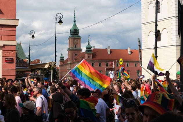 June 13, 2026, Warsaw, Masovian Voivodeship, Poland: People with rainbow pride flags march in front of the Castle Square during the 25th annual Warsaw LGBTQ+ Pride Parade, known in Polish as the Equality Parade. LGBTQ+ people in Poland do not have the right to same-sex civil partnerships, marriage, and child adoption, while also facing homophobia and queerphobia from a largely conservative society. Therefore, the parade is organized primarily as a march for equal rights. Warsaw Poland - ZUMAk204 20260613_zip_k204_020 Copyright: xRomanxKozielx