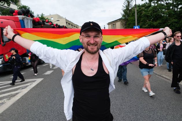 June 13, 2026, Warsaw, Masovian Voivodeship, Poland: A person holds up a rainbow pride flag up behind their shoulders as they march in the 25th annual Warsaw LGBTQ+ Pride Parade, known in Polish as the Equality Parade. LGBTQ+ people in Poland do not have the right to same-sex civil partnerships, marriage, and child adoption, while also facing homophobia and queerphobia from a largely conservative society. Therefore, the parade is organized primarily as a march for equal rights. Warsaw Poland - ZUMAk204 20260613_zip_k204_026 Copyright: xRomanxKozielx