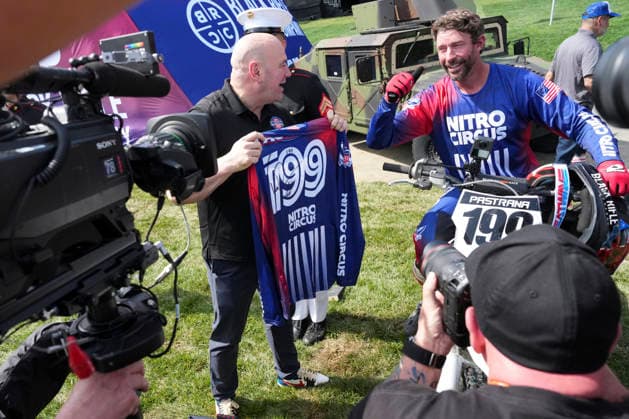 UFC President and CEO Dana White holds the jersey of Travis Pastrana alongside Pastrana following a motorcycle jump ahead of the UFC Freedom 250 fights on the South Lawn of the White House in Washington, DC on Saturday, June 13, 2026.  WASP20260613119 AlexxBrandon