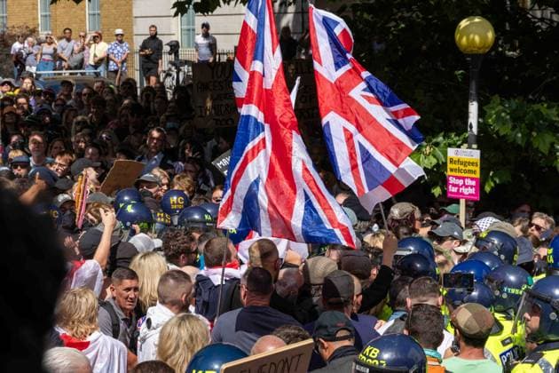 June 13, 2026, Brighton, UK: Brighton, UK. 13 June 2026. Members and supporters of anti-immigration group South East Patriots hold a march through the centre of Brighton. A counter-protest, involving about two dozen groups under the banner of Carnival Against Fascism, has also been taking place at the same time, with police officers keeping the two groups apart. South East Patriots claimed the protest is to demand stronger border control, enforcement of immigration laws, and the deportation of illegal immigrants, with the counter protest groups expressing their resistance against the far right as well as to any form of fascism and racism Brighton UK - ZUMAd99_ 20260613_zap_d99_125 Copyright: xMattxDuckettx