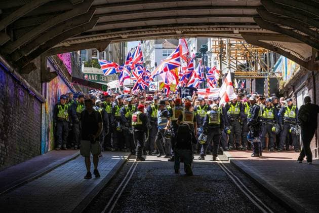 June 13, 2026, Brighton, UK: Brighton, UK. 13 June 2026. Members and supporters of anti-immigration group South East Patriots hold a march through the centre of Brighton. A counter-protest, involving about two dozen groups under the banner of Carnival Against Fascism, has also been taking place at the same time, with police officers keeping the two groups apart. South East Patriots claimed the protest is to demand stronger border control, enforcement of immigration laws, and the deportation of illegal immigrants, with the counter protest groups expressing their resistance against the far right as well as to any form of fascism and racism Brighton UK - ZUMAd99_ 20260613_zap_d99_137 Copyright: xMattxDuckettx