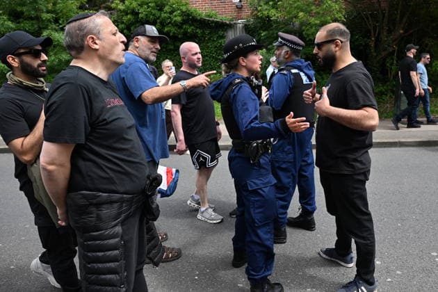June 14, 2026, London, London, UK: London, UK. A Pro Palestinian protester is turned away by police officers as Pro Israeli protesters hold demonstrations near the Edgware United Synagogue who are hosting a Great Israeli Real Estate event. The organisers are allegedly offering to sell stolen Palestinian land including in settlements in the occupied territories. London UK  - ZUMAl94_ 20260614_zaf_l94_027 Copyright: xRayxTangx