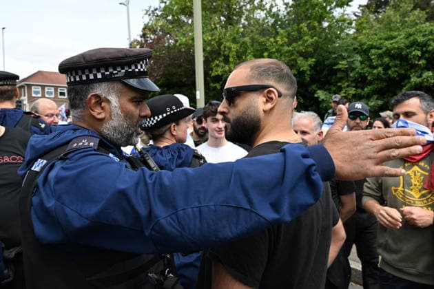 June 14, 2026, London, London, UK: London, UK. A Pro Palestinian protester is turned away by police officers as Pro Israeli protesters hold demonstrations near the Edgware United Synagogue who are hosting a Great Israeli Real Estate event. The organisers are allegedly offering to sell stolen Palestinian land including in settlements in the occupied territories. London UK  - ZUMAl94_ 20260614_zaf_l94_031 Copyright: xRayxTangx