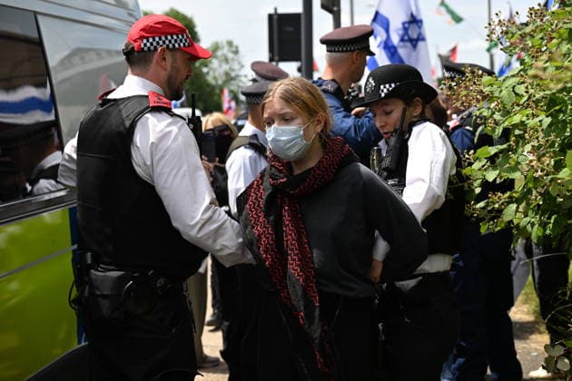 June 14, 2026, London, London, UK: London, UK.A protester is detained by police officers as Pro Palestinian protesters and Pro Israeli protesters clash near the Edgware United Synagogue who are hosting a Great Israeli Real Estate event. The organisers are allegedly offering to sell stolen Palestinian land including in settlements in the occupied territories. London UK  - ZUMAl94_ 20260614_zaf_l94_033 Copyright: xRayxTangx