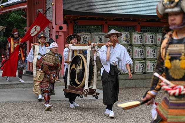 Osaka Keeps Centuries Old Otaue Rice Festival alive OSAKA, JAPAN - JUNE 14: Attendants carry a traditional hanging drum (tsuridaiko) decorated with a mitsutomoe crest as Furyu-musha samurai warriors march past sake barrels during the historic Otaue Rice Planting Festival (Otaue Shinji) at Sumiyoshi Taisha Shrine in southern Osaka, Japan, on June 14, 2026. The ancient agricultural ritual, officially designated as an Important Intangible Folk Cultural Property of Japan, incorporates traditional court music (gagaku), military pageantry, and sacred dances to purify the temple grounds and pray for a bountiful autumn harvest. Artur Widak Anadolu Agency Anadolu Osaka Japan. Editorial use only. Please get in touch for any other usage.  Copyright: x2026xAnadoluxArturxWidak AnadoluxAgencyx