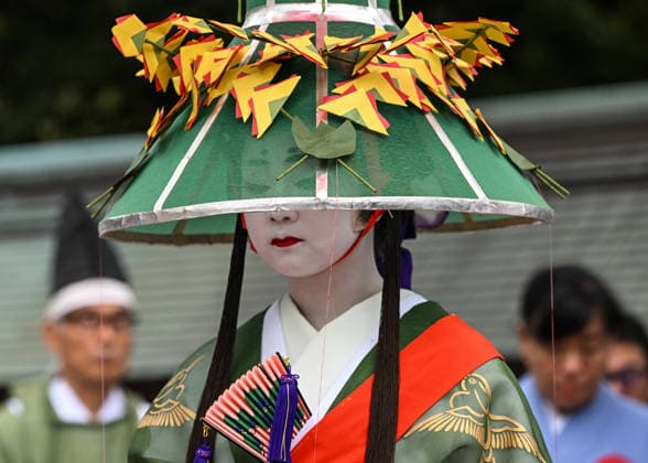 Osaka Keeps Centuries Old Otaue Rice Festival alive OSAKA, JAPAN - JUNE 14: A close-up portrait of a Ueme maiden, dressed in an intricate green crane-patterned kimono and a ceremonial sedge hat, participating in the historic Otaue Rice Planting Festival (Otaue Shinji) at Sumiyoshi Taisha Shrine in southern Osaka, Japan, on June 14, 2026. In this ancient Shinto agricultural ritual, officially designated as an Important Intangible Folk Cultural Property, Ueme maidens are specifically assigned to carry the sacred rice seedlings blessed at the altar, while a group of eight certified Yaotome shrine maidens perform sacred ritual dances to pray for a bountiful harvest. Artur Widak Anadolu Agency Anadolu Osaka Japan. Editorial use only. Please  Copyright: x2026xAnadoluxArturxWidak AnadoluxAgencyx