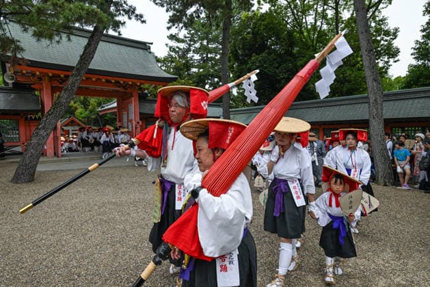 Osaka Keeps Centuries Old Otaue Rice Festival alive OSAKA, JAPAN - JUNE 14: Song leaders (ondotori) carrying large red long-handled umbrellas lead a group of young children participating in the traditional Sumiyoshi Odori dance during the historic Otaue Rice Planting Festival (Otaue Shinji) at Sumiyoshi Taisha Shrine in southern Osaka, Japan, on June 14, 2026. The ancient agricultural ritual, officially designated as an Important Intangible Folk Cultural Property of Japan, concludes its multi-stage festivities with this lively umbrella folk dance to celebrate the completion of the sacred paddy field s planting and pray for a bountiful harvest. Artur Widak Anadolu Agency Anadolu Osaka Japan. Editorial use only. Please get in touch for an  Copyright: x2026xAnadoluxArturxWidak AnadoluxAgencyx