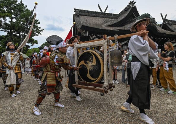 Osaka Keeps Centuries Old Otaue Rice Festival alive OSAKA, JAPAN - JUNE 14: Attendants carry and strike a large traditional hanging drum (tsuridaiko) and a bronze ritual bell as they march in a ceremonial procession from the main shrine buildings toward the sacred paddy field during the historic Otaue Rice Planting Festival (Otaue Shinji) at Sumiyoshi Taisha Shrine in southern Osaka, Japan, on June 14, 2026. The ancient agricultural ritual, officially designated as an Important Intangible Folk Cultural Property of Japan, utilizes rhythmic court music (gagaku) and ceremonial instrumentation during the outdoor march to purify the path and maintain the festive momentum before the sacred planting begins. Artur Widak Anadolu Agency Anadolu O  Copyright: x2026xAnadoluxArturxWidak AnadoluxAgencyx