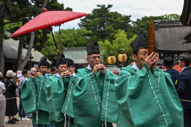 Osaka Keeps Centuries Old Otaue Rice Festival alive OSAKA, JAPAN - JUNE 14: Shinto court musicians (reijin) dressed in traditional green robes play sacred Gagaku wind instruments, including the sho mouth organ and ryuteki bamboo flutes, during a ceremonial procession at the historic Otaue Rice Planting Festival (Otaue Shinji) at Sumiyoshi Taisha Shrine in southern Osaka, Japan, on June 14, 2026. The ancient agricultural ceremony, officially designated as an Important Intangible Folk Cultural Property of Japan, features musicians playing ancient imperial court music during the outdoor march to spiritually purify the path and bless the upcoming rice planting. Artur Widak Anadolu Agency Anadolu Osaka Japan. Editorial use only. Please get i  Copyright: x2026xAnadoluxArturxWidak AnadoluxAgencyx