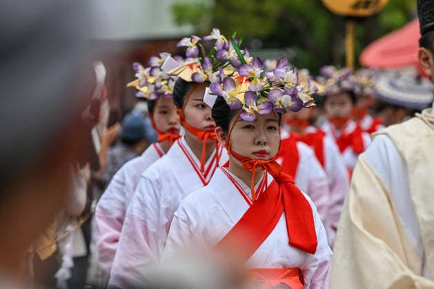 Osaka Keeps Centuries Old Otaue Rice Festival alive OSAKA, JAPAN - JUNE 14: Yaotome shrine maidens, adorned with seasonal purple iris flowers in their hair and wearing traditional white robes and red sashes, march in a ceremonial procession during the historic Otaue Rice Planting Festival (Otaue Shinji) at Sumiyoshi Taisha Shrine in southern Osaka, Japan, on June 14, 2026. The ancient agricultural ritual, officially designated as an Important Intangible Folk Cultural Property of Japan, transitions from the main altar to the outdoor fields, where these eight certified maidens will perform a sacred ritual dance to invoke a bountiful autumn harvest. Artur Widak Anadolu Agency Anadolu Osaka Japan. Editorial use only. Please get in touch for  Copyright: x2026xAnadoluxArturxWidak AnadoluxAgencyx