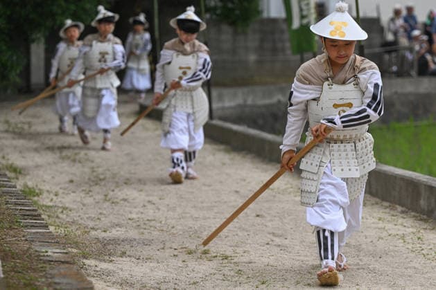 Osaka keeps centuries old Otaue Rice Festival alive OSAKA, JAPAN - JUNE 14: Young children dressed as Chigo-musha (child warriors) wearing white ceremonial infantry armor and jingasa hats march in a line along a dirt path near the paddy field during the historic Otaue Rice Planting Festival (Otaue Shinji) at Sumiyoshi Taisha Shrine in southern Osaka, Japan, on June 14, 2026. The ancient agricultural ritual, officially designated as an Important Intangible Folk Cultural Property of Japan, incorporates local youth in historical military roles to march alongside adults, spiritually guarding the sacred grounds to pray for a bountiful harvest. Artur Widak Anadolu Osaka Japan. Editorial use only. Please get in touch for any other usage.  Copyright: x2026xAnadoluxArturxWidakx