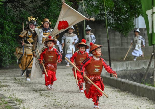 Osaka keeps centuries old Otaue Rice Festival alive OSAKA, JAPAN - JUNE 14: Young children participating as Chigo-musha (child warriors) in red armor run along the path ahead of adult Furyu-musha samurai and standard-bearers during a dramatic charge at the historic Otaue Rice Planting Festival (Otaue Shinji) at Sumiyoshi Taisha Shrine in southern Osaka, Japan, on June 14, 2026. The ancient agricultural ritual, officially designated as an Important Intangible Folk Cultural Property of Japan, includes these spirited, active martial displays by local youth to symbolically drive out evil spirits from the sacred rice field and ensure a successful harvest season. Artur Widak Anadolu Osaka Japan. Editorial use only. Please get in touch for any  Copyright: x2026xAnadoluxArturxWidakx