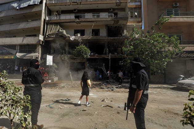 June 14, 2026, Beirut, Beirut, Lebanon: Members of Lebanese army intelligence secures that site of a building that was targeted by Israeli strike in Beirut southern suburb, a bastion of pro-Iranian Hezbollah, as a resident looks at looks at damage. Three people were killed in the attack, according to Lebanon s state media. The Israel Defense Forces (IDF) said it targeted a command center used by Hezbollah after the Iran-backed armed group launched aerial targets toward Israel Beirut Lebanon - ZUMAn313 20260614_zip_n313_009 Copyright: xMarwanxNaamanix