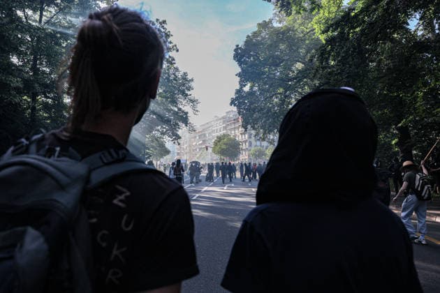 June 14, 2026, Geneva, Switzerland, European Union: Two protesters watch from a distance as others run from tear gas fired by police during a demonstration in Geneva ahead of the G7 summit. Geneva European Union - ZUMAo116 20260614_znp_o116_009 Copyright: xBiancaxOterox