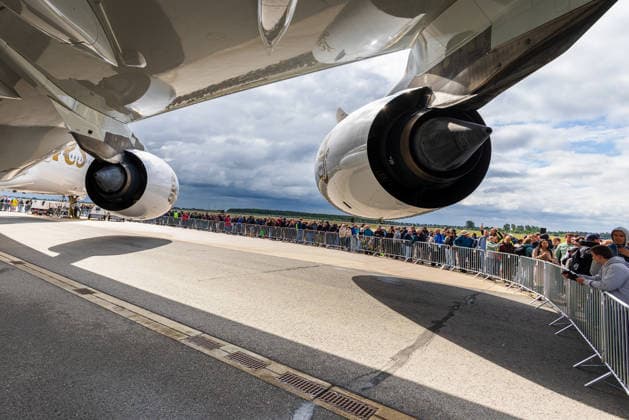 Publikumstag auf ILA Berlin 2026, Berlin, 14.06.2026 Blick unter den Tragflächen eines Emirates Airbus A380 hindurch: Zahlreiche Besucher stehen hinter Absperrgittern und warten auf die Besichtigung des Großraumjets. Wechselhaftes Wetter mit Quellwolken und zwischenzeitlichem Starkregen prägte den Publikumstag. Schöneberg Berlin ExpoCenter Airport Brandenburg Deutschland *** Public Day at ILA Berlin 2026, Berlin, 14 06 2026 View under the wings of an Emirates Airbus A380 Numerous visitors stand behind barriers and wait to see the wide-bodied jet Changeable weather with spring clouds and intermittent heavy rain characterized the Public Day Schöneberg Berlin ExpoCenter Airport Brandenburg Germany 20260614-1V9A4431-M4000