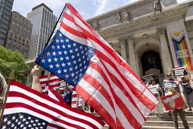 June 14, 2026, New York, New York, USA: Demonstrators join Rise and Resist s We Are In A State Of Emergency Flag Day anti-Trump protest on the steps of the New York Public Library (NYPL) branch on Fifth Avenue in Midtown Manhattan. People hold upside down flags and signs that read TERRORIST with an image of President Trump. New York USA  - ZUMAr174 20260614_znp_r174_006 Copyright: xGinaxMxRandazzox