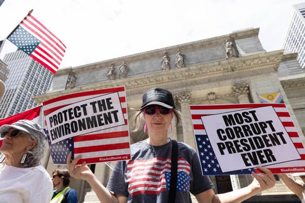 June 14, 2026, New York, New York, USA: Demonstrators join Rise and Resist s We Are In A State Of Emergency Flag Day anti-Trump protest on the steps of the New York Public Library (NYPL) branch on Fifth Avenue in Midtown Manhattan. People have upside down flags and signs that read PROTECT THE ENVIRONMENT MOST CORRUPT PRESIDENT EVER New York USA  - ZUMAr174 20260614_znp_r174_009 Copyright: xGinaxMxRandazzox