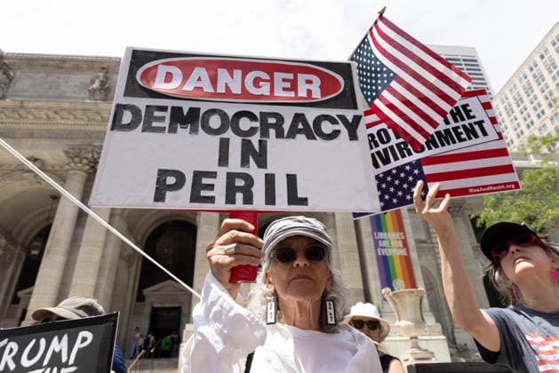 June 14, 2026, New York, New York, USA: Demonstrators join Rise and Resist s We Are In A State Of Emergency Flag Day anti-Trump protest on the steps of the New York Public Library (NYPL) branch on Fifth Avenue in Midtown Manhattan. People have upside down flags and signs that read DANGER DEMOCRACY IN PERIL New York USA  - ZUMAr174 20260614_znp_r174_010 Copyright: xGinaxMxRandazzox