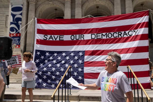 June 14, 2026, New York, New York, USA: Demonstrators join Rise and Resist s We Are In A State Of Emergency Flag Day anti-Trump protest on the steps of the New York Public Library (NYPL) branch on Fifth Avenue in Midtown Manhattan where a giant upside down flag is hoisted reading SAVE OUR DEMOCRACY. New York USA - ZUMAr174 20260614_znp_r174_013 Copyright: xGinaxMxRandazzox