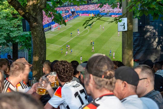 Public Viewing in einem Münchner Biergarten, Fußballfans mit Deutschlandtrikot verfolgen das Spiel Deutschland-Curacao, das mit einem 7:1-Sieg für die deutsche Mannschaft endet, Fußball-WM, München, 14. Juni 2026 Deutschland, München, 14. Juni 2026, Public Viewing in einem Münchner Biergarten, Fußballfans mit Deutschlandtrikot verfolgen das Spiel Deutschland-Curacao, das mit einem 7:1-Sieg für die deutsche Mannschaft endet, der Biergarten Michaeligarten hat eine große LED-Leinwand aufgestellt, hunderte Besucher schauen sich das erste Spiel der deutschen Mannschaft an, ARD Live-Übertragung ab 19 Uhr aus Houston, USA, Fußball-WM, FIFA Fußball-Weltmeisterschaft, Fußball, Sport, Gastronomie, *** Public viewing in a Munich beer g