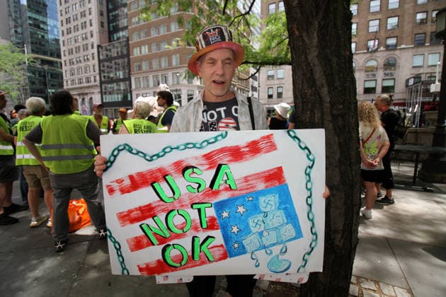 June 14, 2026, Manhattan, New York, USA: New York, New York June 14,.2026... The group Rise and Resist today protested President Trump by flying a 12 x 18 foot Ã¢â‚¬oedistressedÃ¢â‚¬Â American flag in front of a place free of Trump & Republicans, the steps of the New York Public Library. Manhattan USA  - ZUMAct2_ 20260614_faf_ct2_022 Copyright: xBrucexCotlerx