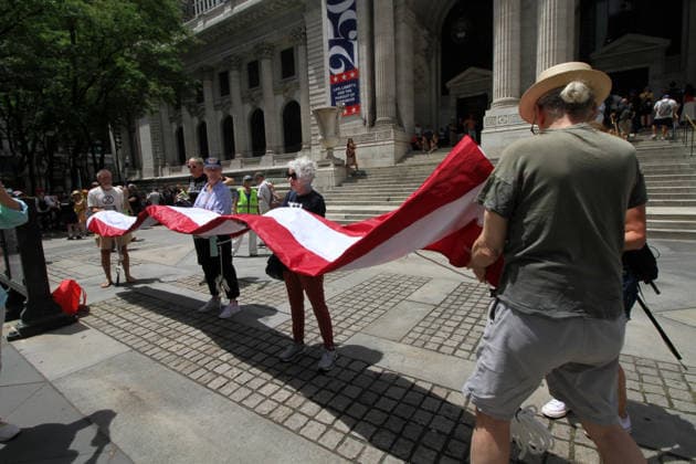 June 14, 2026, Manhattan, New York, USA: New York, New York June 14,.2026... The group Rise and Resist today protested President Trump by flying a 12 x 18 foot Ã¢â‚¬oedistressedÃ¢â‚¬Â American flag in front of a place free of Trump & Republicans, the steps of the New York Public Library. Manhattan USA  - ZUMAct2_ 20260614_faf_ct2_031 Copyright: xBrucexCotlerx