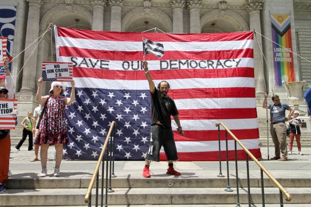 June 14, 2026, Manhattan, New York, USA: New York, New York June 14,.2026... The group Rise and Resist today protested President Trump by flying a 12 x 18 foot Ã¢â‚¬oedistressedÃ¢â‚¬Â American flag in front of a place free of Trump & Republicans, the steps of the New York Public Library. Manhattan USA  - ZUMAct2_ 20260614_faf_ct2_039 Copyright: xBrucexCotlerx