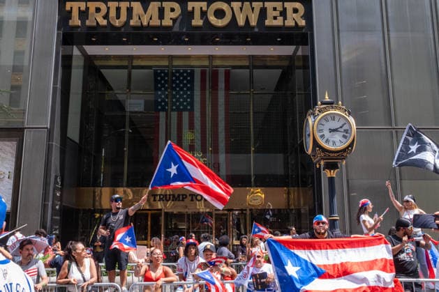 June 14, 2026, New York, New York, USA: A man waves a giant Puerto Rican flag in front of Trump Tower as the 69th Puerto Rican Day Parade makes its way up Fifth avenue. New York USA  - ZUMAp288 20260614_znp_p288_019 Copyright: xSyndixPilarx
