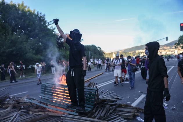 June 14, 2026, Geneva, Switzerland, European Union: A protester holds a fist in the air while standing on a burning bench during demonstrations in Geneva ahead of the G7 summit, which begins tomorrow in Evian-les-Bains. Geneva European Union  - ZUMAo116 20260614_znp_o116_021 Copyright: xBiancaxOterox