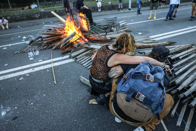 June 14, 2026, Geneva, Switzerland, European Union: A woman puts her arm around a man as he lights a fire next to a burning bench during demonstrations in Geneva ahead of the G7 summit, which begins tomorrow in Evian-les-Bains. Geneva European Union  - ZUMAo116 20260614_znp_o116_023 Copyright: xBiancaxOterox