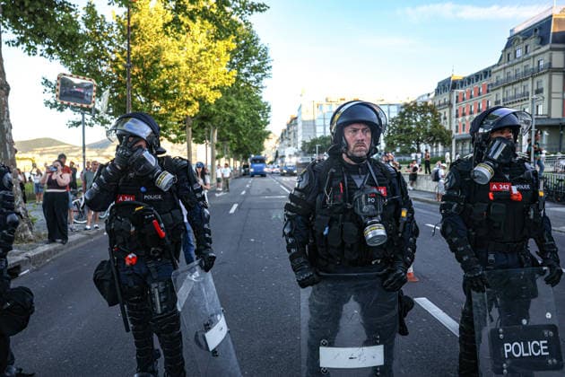 June 14, 2026, Geneva, Switzerland, European Union: An officer covers his face while others stand in a cordon during demonstrations in Geneva ahead of the G7 summit, which begins tomorrow in Evian-les-Bains. The protest disrupted traffic and movement throughout the city and toward Evian-les-Bains. Geneva European Union - ZUMAo116 20260614_znp_o116_026 Copyright: xBiancaxOterox
