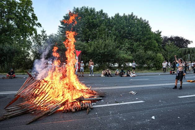 June 14, 2026, Geneva, Switzerland, European Union: A man holds his fist in the air and watches as a fire burns from debris in the street during demonstrations in Geneva ahead of the G7 summit, which begins tomorrow in Evian-les-Bains. Geneva European Union - ZUMAo116 20260614_znp_o116_029 Copyright: xBiancaxOterox