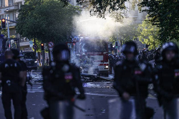 June 14, 2026, Geneva, Switzerland, European Union: Police officers in riot gear stand as a fire truck is seen through lingering tear gas smoke during demonstrations in Geneva ahead of the G7 summit, which begins tomorrow in Evian-les-Bains. Geneva European Union  - ZUMAo116 20260614_znp_o116_043 Copyright: xBiancaxOterox