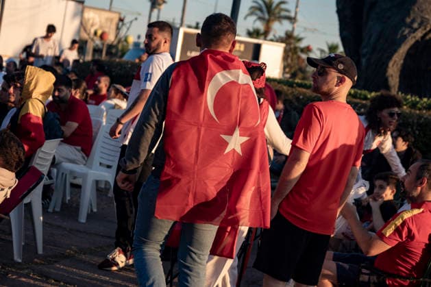 Turkish Fans Gather for the Match A Turkish fan draped in a national flag walks through a seaside park where supporters gather to watch the FIFA World Cup Group D match between Turkey and Australia on a giant screen in the Konak district of Izmir, Turkey, on June 14, 2026. This marks Turkey s first appearance in the FIFA World Cup finals since the 2002 tournament. Turkey finished third at the 2002 FIFA World Cup. Izmir Izmir Turkey Copyright: xMuratxKocabasx