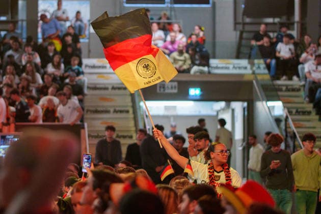 Germany Victory Celebrations Disrupt Traffic in Kassel Germany - Kassel, 14.06.2026 A woman waves germany flag (center down), as Germany supporters celebrate following Germany s 7-1 victory over Curacao in a FIFA World Cup 2026 Group E match. Large crowds gathered near the Auestadion and the Probonio Arena public viewing site, blocking traffic, climbing onto vehicles and waving German flags during spontaneous post-match celebrations. Police later secured the area. Hesse