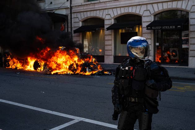 Manifestation contre le sommet du G7 à Genève le 14 juin 2026 Nicolas Liponne MAXPPP Geneve 14 06 2026 A police officer stands in front of a burning Tesla, set ablaze by members of the Black Bloc, during the international demonstration against fascism, capitalism, and imperialism, as part of the mobilization of the counter G7 summit, to be held in Evian from June 15 to 17, in Geneva on June 14, 2026 A police officer stands in front of a burning Tesla, set ablaze by members of the Black Bloc, during the international demonstration against fascism, capitalism, and imperialism, as part of the protests against the G7 summit, which will take place in Evian from June 15 to 17, in Geneva on June 14, 2026 Geneve Geneve SUISSE  Copyright: xMAXPPPxNicolasxLiponnex NLP202606152301 NLP202606152301