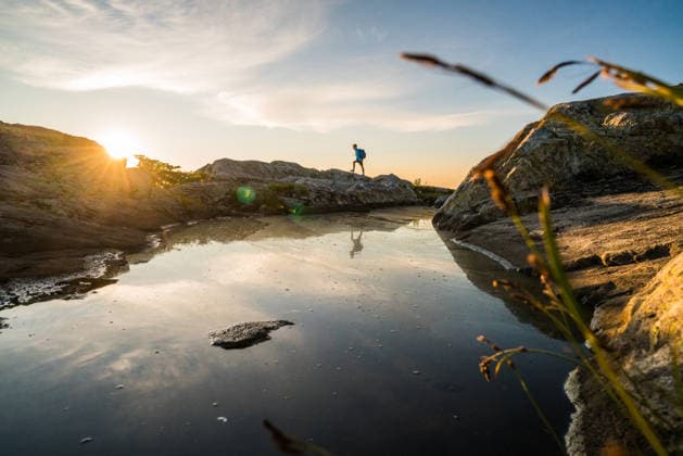 Man hiking on rocks near water at sunset Vancouver, British Columbia, Canada CR_JDIP260614B-2050726-01 ,model released, Symbolfoto