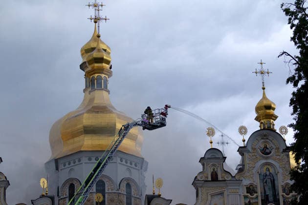 A firefighter stands in an aerial platform as he extinguishes a fire on the roof of the Dormition Cathedral at the Kyiv Pechersk Lavra, caused by a massive Russian combined attack, Kyiv, Ukraine, June 15, 2026. The Russian army launched a large-scale assault on the Ukrainian capital with missiles and strike drones, killing four people and injuring 28, including children and a pregnant woman. At least 140,000 consumers were left without electricity due to damage to power grids. Residential buildings, the Kyiv Pechersk Lavra, the Mystetskyi Arsenal Museum Complex, the Dovzhenko Film Studio, and the building of the High Anti-Corruption Court sustained damage. (Photo by Kyrylo Chubotin Ukrinform) Massive Russian attack damages Kyiv Pechersk Lav  Copyright: xKirillxChubotinx