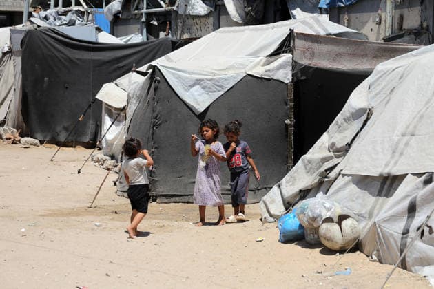 Displaced children play among ruins in western Gaza City Palestinian children play near tents sheltering displaced families amid the rubble of destroyed buildings in western Gaza City on June 15, 2026, as temperatures rise and humanitarian conditions continue to deteriorate. Displaced residents face growing challenges due to damaged infrastructure and shortages of basic services, while cases of skin diseases among children are increasing in displacement camps and shelters across the Gaza Strip. Photo by Bilal Osama apaimages Gaza city Gaza Strip Palestinian Territory 150626_Gaza_BO_02(13) Copyright: xapaimagesxBilalxOsamax xapaimagesx