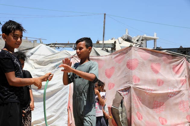 Displaced children play among ruins in western Gaza City Palestinian children play near tents sheltering displaced families amid the rubble of destroyed buildings in western Gaza City on June 15, 2026, as temperatures rise and humanitarian conditions continue to deteriorate. Displaced residents face growing challenges due to damaged infrastructure and shortages of basic services, while cases of skin diseases among children are increasing in displacement camps and shelters across the Gaza Strip. Photo by Bilal Osama apaimages Gaza city Gaza Strip Palestinian Territory 150626_Gaza_BO_02(10) Copyright: xapaimagesxBilalxOsamax xapaimagesx