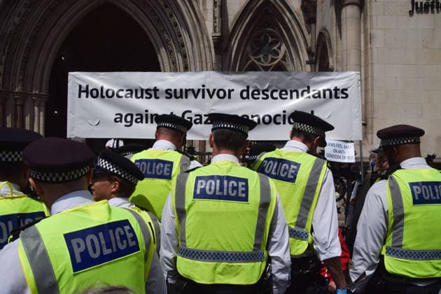 June 15, 2026, London, England, United Kingdom: Police officers arrest protesters sitting under a banner stating Holocaust survivor descendants against Gaza genocde outside the Royal Courts of Justice as the ban on the activist group Palestine Action is ruled as lawful by the Court of Appeal. Judges have overturned a previous ruling that the ban on the group was wrong. Protesters sat outside the court with placards stating Ã¢â‚¬ËœSaving lives is not terrorism, I support Palestine ActionÃ¢ London United Kingdom  - ZUMAv130 20260615_zip_v130_013 Copyright: xVukxValcicx