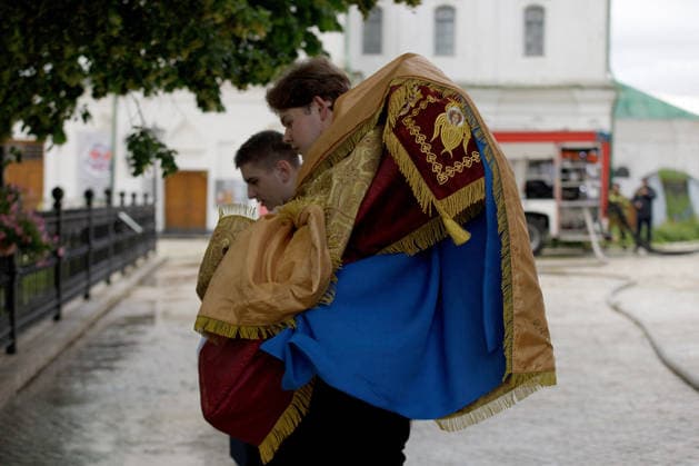 Massive Russian Attack Damages Kyiv Pechersk Lavra and Mystetskyi Arsenal - Kyiv Two young men hold religious banners at the Kyiv Pechersk Lavra, where the roof of the Dormition Cathedral caught fire during a massive Russian combined attack, Kyiv, Ukraine, June 15, 2026. The Russian army launched a large-scale assault on the Ukrainian capital with missiles and strike drones, killing four people and injuring 28, including children and a pregnant woman. At least 140,000 consumers were left without electricity due to damage to power grids. Residential buildings, the Kyiv Pechersk Lavra, the Mystetskyi Arsenal Museum Complex, the Dovzhenko Film Studio, and the building of the High Anti-Corruption Court sustained damage. (Photo by Marianna Kotyk  Copyright: xUkrinform ABACAx