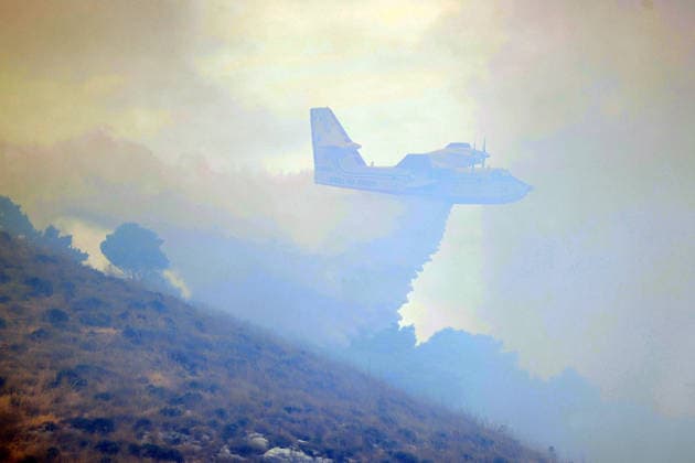 IPA85724855 - A LARGE MOUNTAIN FIRE IN SALEMI, NEAR TRAPANI, HAS BEEN BURNING FOR THREE DAYS; 1,200 HECTARES OF FOREST HAVE GONE UP IN SMOKE. Pictured: a Canadair aircraft in action over the fire  Copyright: xAlbertoxLoxBiancox xAlbertoxLoxBianco Fotogrammax 85724855