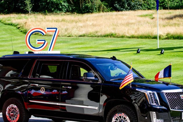 June 15, 2026, Evian-Les-Bains, Haute-Savoie, France: EVIAN-LES-BAINS, FRANCE - JUNE 15, 2026: The U.S. presidential armored limousine, flying American flags, arrives at the HoÂ tel Royal ahead of high-level meetings. A security officer stands ready to open the vehicle s door, with a manicured lawn featuring a large G7 sign visible in the background, marking the official setting of the 52nd G7 Summit in o°vian-les-Bains. Evian-Les-Bains France  - ZUMAc267 20260615_zip_c267_011 Copyright: xMarcoxCordonex