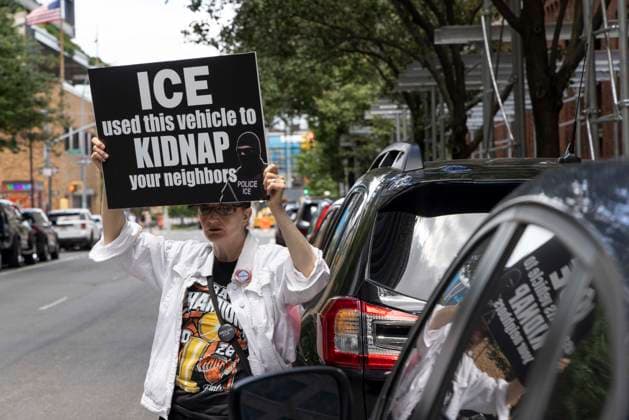 June 15, 2026, New York, New York, USA: An anti-ICE (Immigration Customs and Enforcement) demonstrator holds a sign reading ICE used this vehicle to KIDNAP your neighbors with an image of a masked agent wearing a vest that reads POLICE ICE, identifying a car parked on the street near the Department of Justice Immigration Courts at 201 Varick Street. Recently Border Czar T. Homan threatened to send a surge of immigration agents to New York City after Governor Hochul signed legislation barring state and local law enforcement from working with immigration in New York jails. New York USA - ZUMAr174 20260615_znp_r174_011 Copyright: xGinaxMxRandazzox