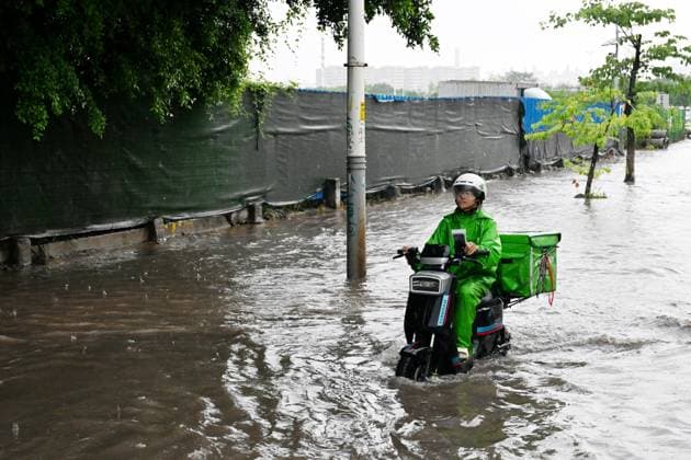 GUANGZHOU, CHINA - JUNE 15: A deliveryman rides through waterlogged road on June 15, 2026 in Guangzhou, Guangdong Province of China. Multiple districts in Guangzhou on June 15 issued orange alert for rainstorms due to continuous influence of strong thunderstorm clouds.  Copyright: xChinaxNewsxServicex 111648333525