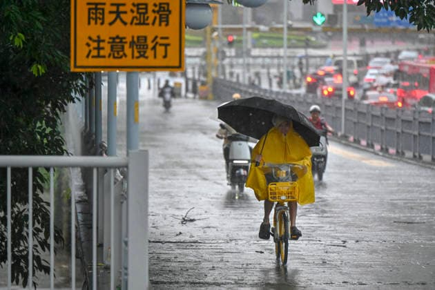 GUANGZHOU, CHINA - JUNE 15: A resident with umbrella rides in the rain on June 15, 2026 in Guangzhou, Guangdong Province of China. Multiple districts in Guangzhou on June 15 issued orange alert for rainstorms due to continuous influence of strong thunderstorm clouds.  Copyright: xChinaxNewsxServicex 111648333532