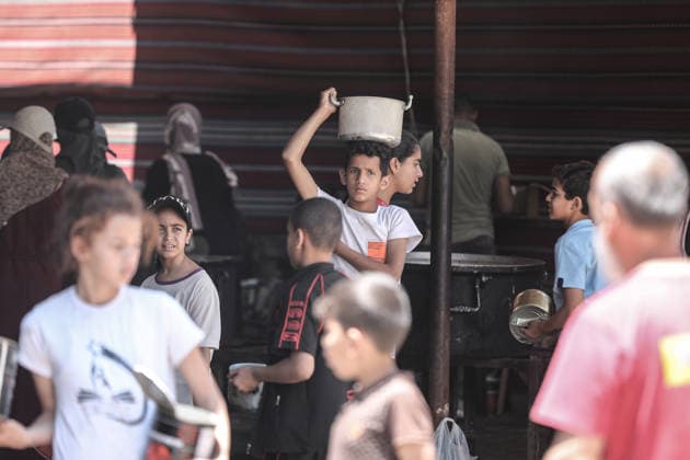 Hot meals distributed to displaced Palestinians in Gaza DEIR AL-BALAH, GAZA, PALESTINE - JUNE 16: A Palestinian boy carries a pot of food distributed by a charity in Nuseirat Camp, as the food crisis continues due to ongoing Israeli attacks on the Gaza Strip and limited humanitarian aid access, in Deir al-Balah, Gaza, Palestine, on June 16, 2026. Moiz Salhi Anadolu Deir al-Balah Gaza. Editorial use only. Please get in touch for any other usage.  Copyright: x2026xAnadoluxMoizxSalhix