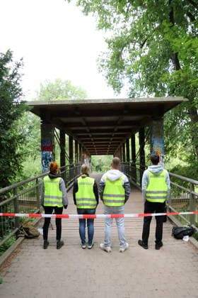 Helfer stehen an einer Absperrung auf einer Brücke im Nuthepark während der Entschärfung einer Fliegerbombe aus dem Zweiten Weltkrieg in Potsdam, 16. Juni 2026. Bombenentschärfung in Potsdam *** Rescue workers stand behind a barrier on a bridge in Nuthepark during the defusing of a World War II aerial bomb in Potsdam, June 16, 2026 Bomb disposal in Potsdam,detected_source_language